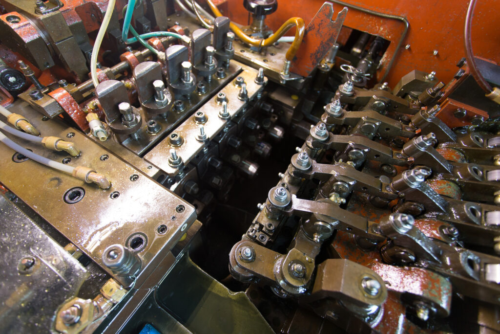 Close up on a metal production line cold forming machine, no people are visible.